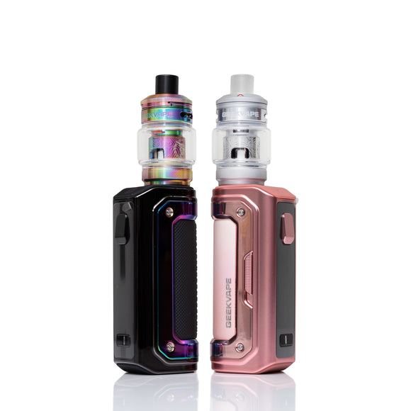 Two Geekvape portable vape devices standing side by side on a white reflective background. The left device is black with an iridescent rainbow-colored tank.
