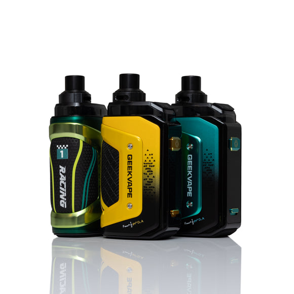 Three Geekvape R1 Racing vape devices standing upright on a reflective white surface. The devices feature three different color options: a metallic green and black, a bright yellow and black, and a teal and black gradient.