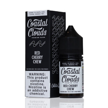 A bottle of Coastal Clouds Red Cherry Chew premium vapor liquid next to its black packaging box, displayed on a clean white background with a subtle reflection.