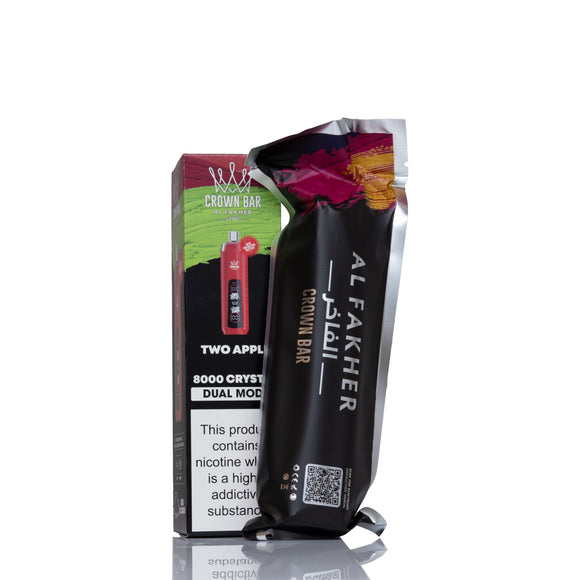A black Al Fakher Brown Bar vape device stands in front of its retail box on a white background. The packaging features green, red, and black graphics with the brand name 'Crown Bar' and flavor text 'Two Apple'.