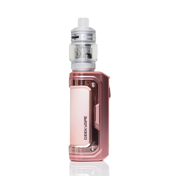 A GEEKVAPE electronic vape device in a metallic rose gold finish, featuring a clear glass tank with silver coils and a white mouthpiece, set against a plain white background with a subtle reflection.