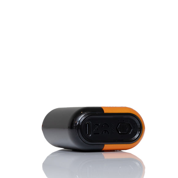 A close-up of a black and orange electronic device, showing a USB-C port and a small circular button, on a reflective white surface.