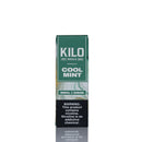 A tall rectangular vape pen box labeled 'KILO COOL MINT' in green and white, with a black nicotine warning panel near the bottom, photographed on a white background with a faint reflection below.