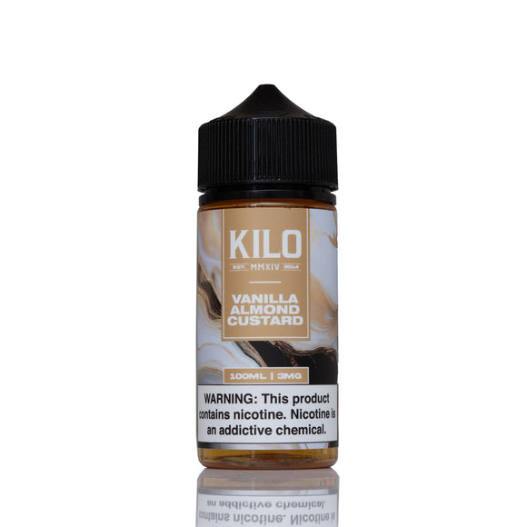 A 100ml bottle of Kilo Vanilla Almond Custard e-liquid on a white background with a reflection below. The bottle has a black cap and a label featuring brown and beige tones with vanilla and almond imagery.