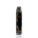 A black and gold Oxva vape device with a carbon fiber pattern, standing vertically on a reflective white surface.