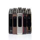 Five vape devices standing upright in a row on a white reflective surface. The devices have different color options: black carbon fiber, brown, silver, dark red, and black with gold accents.